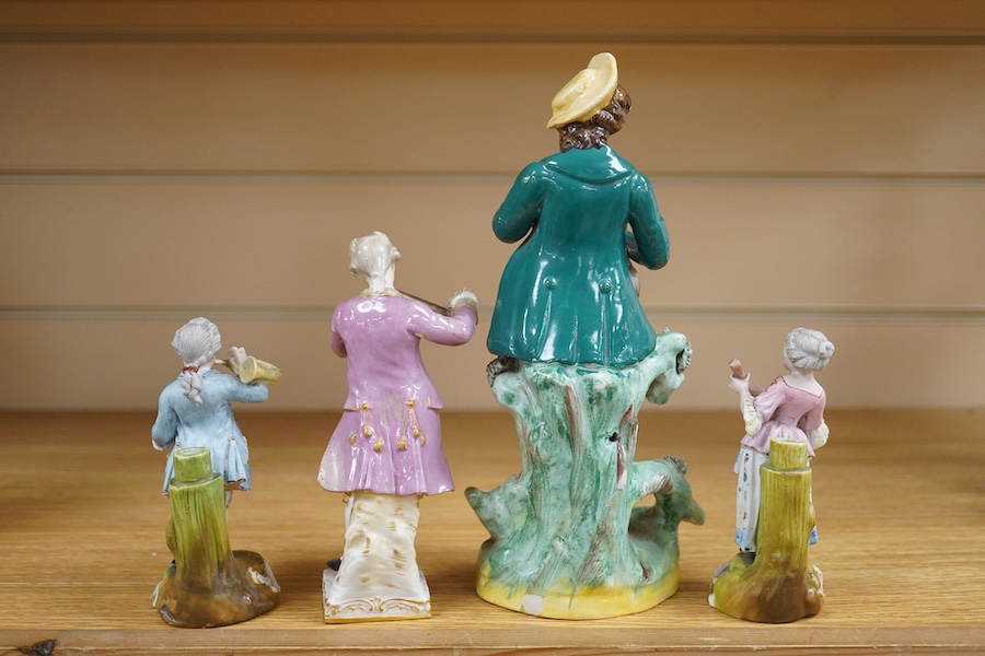 A mid 19th century Staffordshire figure wearing a green jacket, a Berlin KPM figure of a violinist and two coloured biscuit musicians, tallest 23cm. Condition - fair to good